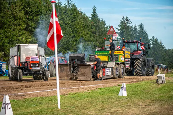 Aarhus, Danimarka. 16 Ağustos 2025 Güçlü makinelerin neşeli festival kalabalığından önce ağır topları çamura sürüklediği bir yarışma..