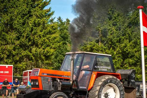 Aarhus, Danimarka. 16 Ağustos 2025 Güçlü makinelerin neşeli festival kalabalığından önce ağır topları çamura sürüklediği bir yarışma..