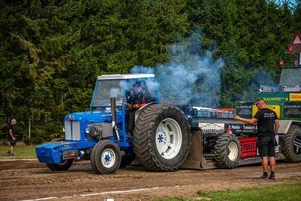Aarhus, Danimarka. 16 Ağustos 2025 Güçlü makinelerin neşeli festival kalabalığından önce ağır topları çamura sürüklediği bir yarışma..