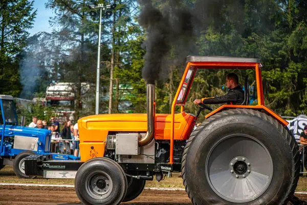 Aarhus, Danimarka. 16 Ağustos 2025 Güçlü makinelerin neşeli festival kalabalığından önce ağır topları çamura sürüklediği bir yarışma..