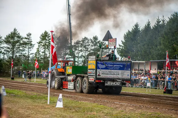 Aarhus, Danimarka. 16 Ağustos 2025 Güçlü makinelerin neşeli festival kalabalığından önce ağır topları çamura sürüklediği bir yarışma..