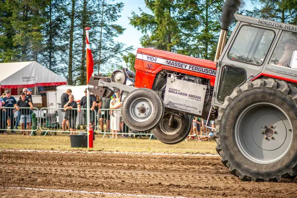 Aarhus, Danimarka. 16 Ağustos 2025 Güçlü makinelerin neşeli festival kalabalığından önce ağır topları çamura sürüklediği bir yarışma..