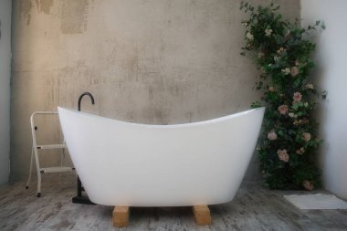 Beyaz küvetli ve çiçekli küvet.