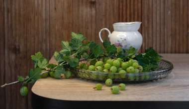 Ahşap arka planı olan ahşap bir kasede taze yeşil bektaşi üzümü.