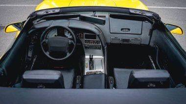 An overhead view of a contemporary convertible car with an opulent black interior and a sleek yellow exterior.  clipart