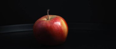 Sağlıklı beslenme kavramları için ideal siyah bir zemine karşı ıslak bir elmanın makro çekimi..