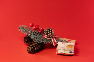 Doğal dekorasyonların yer aldığı Noel kompozisyonu ve sıcak bir tatil ortamı için paketlenmiş hediyeler.