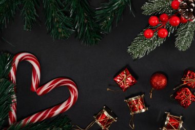 Siyah arka planda noel ağacı dalları ile noel kompozisyonu