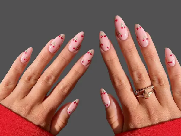 Renkli ve süslü manikürlü modern moda yaratıcı şekilleri ve gri arkaplan çizimleri olan genç bir kadının elleri ve parmakları. 