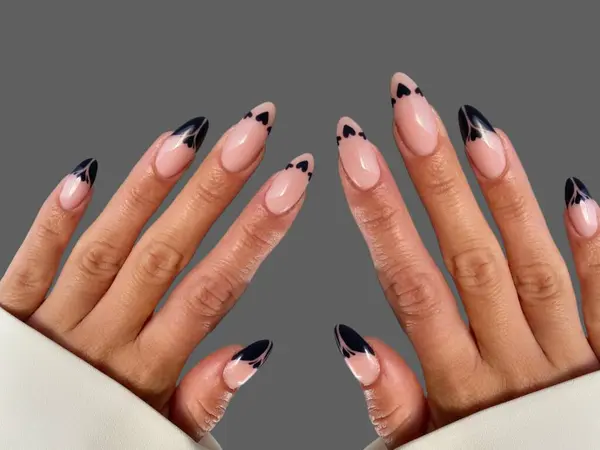 Renkli ve süslü manikürlü modern moda yaratıcı şekilleri ve gri arkaplan çizimleri olan genç bir kadının elleri ve parmakları. 