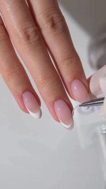 Manikür yapan genç bir kadının elleri ve parmakları manikür yapıyor. Tırnak ve kişisel bakım salonlarında modern ve zarif şekiller sergiliyor. Güzellik salonunda profesyonel manikür. 