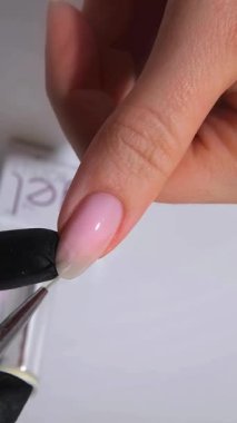 Manikür yapan genç bir kadının elleri ve parmakları manikür yapıyor. Tırnak ve kişisel bakım salonlarında modern ve zarif şekiller sergiliyor. Güzellik salonunda profesyonel manikür. 