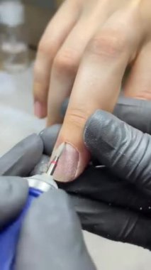 Genç bir kadının elleri tırnaklarını yıkar ve oje temizler ve manikür uygular ve manikürcüye manikür yapar..