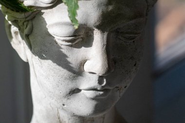 Huzurlu bir bahçe heykelinin yakın çekimi, yapraklı bir taç, huzur verici varlığını arttırmak için güzelce aydınlatılmış.