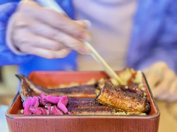 Baharatlı soslu ızgara saba pirinç kasesi, üstüne zencefil turşusu, Japon mutfağında mükemmel bir lezzet dengesi sunuyor.