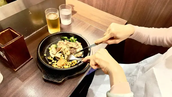 Cızırdayan, canlı kenarlı tavuk bifteği, duyguları cezbediyor. Kadın ustalıkla bıçak ve çatal kullanıyor. Rengarenk sebzelerle dolu mükemmel pişirilmiş yemeğin tadını çıkarmak için hazırlanıyor.