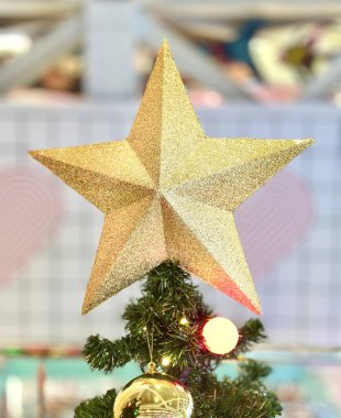 Golden star ornament with five points adorning the top of a Christmas tree Embracing the holiday spirit, it brings a sense of joy and hope Perfect for seasonal decorations or holiday-themed projects symbolizing Christmas arrival clipart