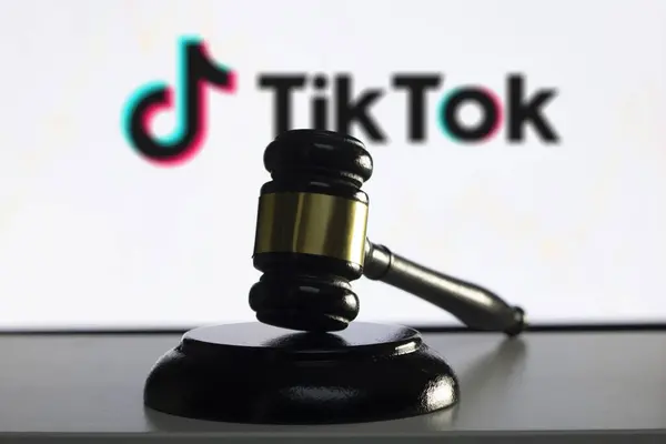 Arka planda TikTok logosu olan tahta bir tokmak..