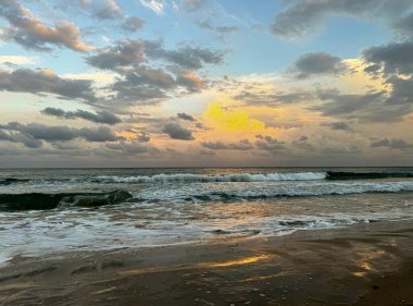 Sahilde deniz batımı olan manzara