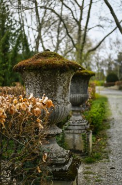 Old stone columns from the 19th century overgrown with moss and patina clipart