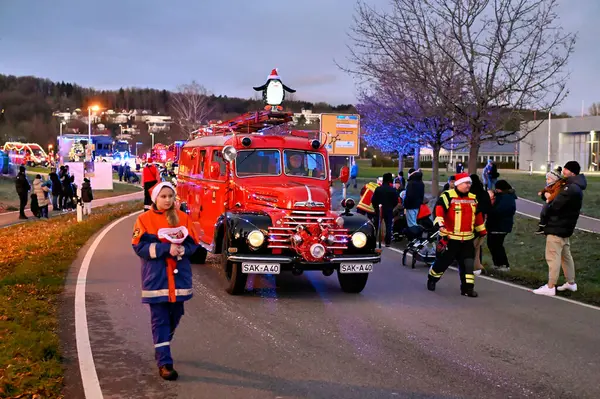 Noel zamanı çocuklar için Rheinfelden 'daki itfaiye teşkilatının mavi ışık geçidi. Eski model itfaiye aracı iş başında.