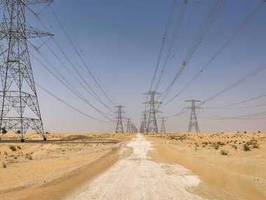 Geniş Dubai çölünde uzaktan kumfırtınalı elektrik hatları var.
