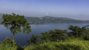 Umiam Lake, Shillong, is a man-made reservoir offering boating, fishing, and stunning views. Surrounded by lush hills. clipart