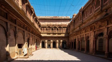 Bikaner 'deki Junagarh Kalesi' nin merkezi bir avlusu, karmaşık şekilde oyulmuş saraylar ve pavyonlarla çevrili sakin bir alanı var.