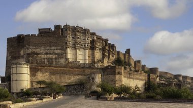 Mehrangarh Kalesi, Jodhpur, Hindistan 'daki görkemli bir tepe kalesi, 180 metrelik bir uçurumun üzerinde duruyor. 1459 yılında Rao Jodha tarafından inşa edilen bina, yüksek duvarlar, yedi kapı ve karmaşık bir şekilde oyulmuş saraylar da dahil olmak üzere etkileyici bir mimari sergiliyor..