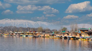 Kaşmir 'in Srinagar kentindeki Dal Gölü' ndeki yüzen evler eşsiz ve unutulmaz bir deneyim sunuyor. Bu geleneksel ahşap tekneler gölün sakin sularında yüzerken konforlu bir konaklama sağlar..