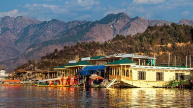 Kaşmir 'in Srinagar kentindeki Dal Gölü' ndeki yüzen evler eşsiz ve unutulmaz bir deneyim sunuyor. Bu geleneksel ahşap tekneler gölün sakin sularında yüzerken konforlu bir konaklama sağlar..