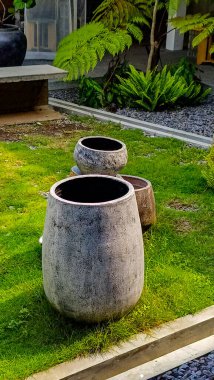 Dört dekoratif bahçe tenceresinin yer aldığı canlı bir açık hava sahnesi iyi korunmuş bir çimenliğe yerleştirilmiş çeşitli doku ve renklerde..