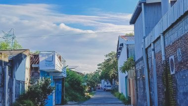 Köyün ortasında bir yol. Renkli binalar. Bulutlarla dolu mavi gökyüzü