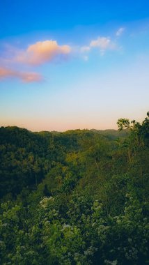 Bereketli bir yeşilliği ve güzel bir gündoğumu olan sakin bir dağ vadisi. Sabahın erken saatlerinde manzara üzerinde yumuşak pastel renkler bırakır, huzurlu ve huzurlu bir ortam yaratır..