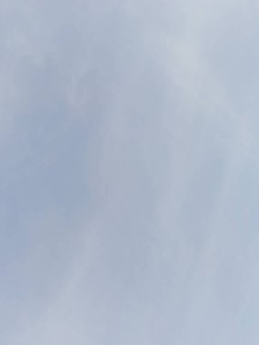 Yumuşak bulutlu berrak mavi bir gökyüzünün sakin bir arkaplan görüntüsü sunuyor. Barışçıl, doğayla ilgili konular için idealdir ve basitlik ve boşluğu vurgular.