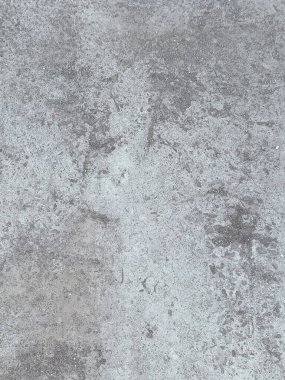 Birkaç renk lekesi olan gri ve beyaz bir duvar. Duvar betondan yapılmış ve pürüzlü bir dokusu var.
