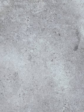Birkaç renk lekesi olan gri ve beyaz bir duvar. Duvar betondan yapılmış ve pürüzlü bir dokusu var.