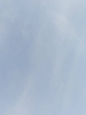 Yumuşak bulutlu berrak mavi bir gökyüzünün sakin bir arkaplan görüntüsü sunuyor. Barışçıl, doğayla ilgili konular için idealdir ve basitlik ve boşluğu vurgular.