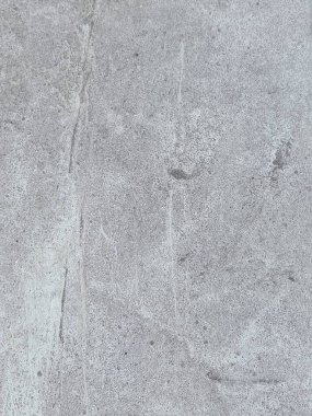 Birkaç renk lekesi olan gri ve beyaz bir duvar. Duvar betondan yapılmış ve pürüzlü bir dokusu var.