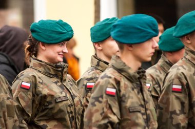 Varşova, Polonya - 15 Ağustos 2014: Silahlı Kuvvetler Günü kutlamaları sırasında koyu yeşil bereliler takmış bir grup Polonyalı asker gülümsüyor, bekliyor.