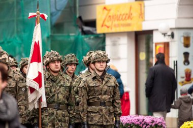 Warsaw, Poland - August 15 2014: a group of Polish soldiers standing still during the celebration of the Armed Forces Day, banner visible in front clipart