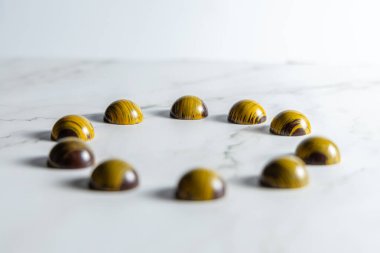 Beyaz mermer arka planda çikolatalı şekerler, seçici odak