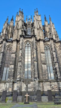 Görüntü Gotik bir katedrali gösteriyor. Uzun, sivri uçlu bir mimarisi var. Burası Almanya 'daki Köln Katedrali..