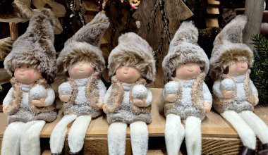 Kış karakterlerinin figürleri arka arkaya oturuyor. Her biri yumuşak, hafif kıyafetler giymiş ve tüylü bir şapkaları var. Ellerinde kartopu tutuyorlar..