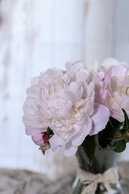 Fotoğraf, şeffaf cam bir vazoda duran zarif pembe şakayık buketini gösteriyor..