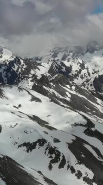 Karlı dağ tepeleri ve vadiler berrak bir gökyüzünün altında.