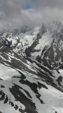 Kış manzarasında karla kaplı dağlar ve donmuş tepeler.