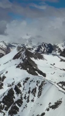 Kışın görkemli karla kaplı dağların havadan görünüşü.