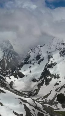 Kışın karla kaplı dağ zirvelerinin çarpıcı manzarası.