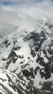 Görkemli kar örtülü dağlar berrak mavi gökyüzüne karşı.